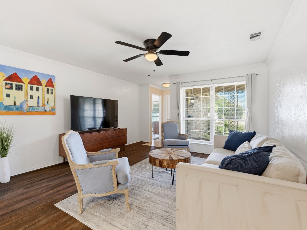 Unwind in your bright living room with plush seating, elegant furnishings, and natural light streaming through French doors—your peaceful retreat awaits.