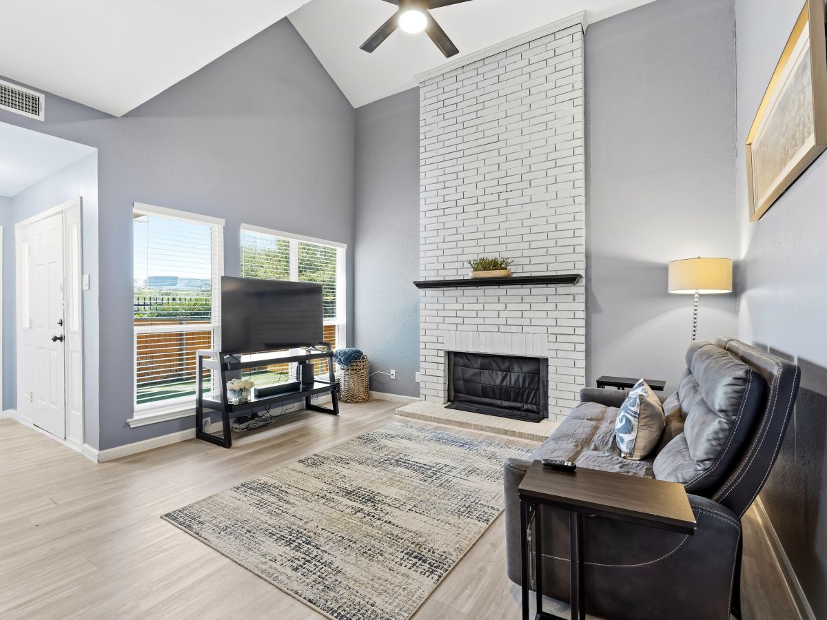 Unwind in your spacious living room with soaring ceilings, cozy fireplace, and serene glimpses of the water beyond. The perfect retreat after a day exploring.