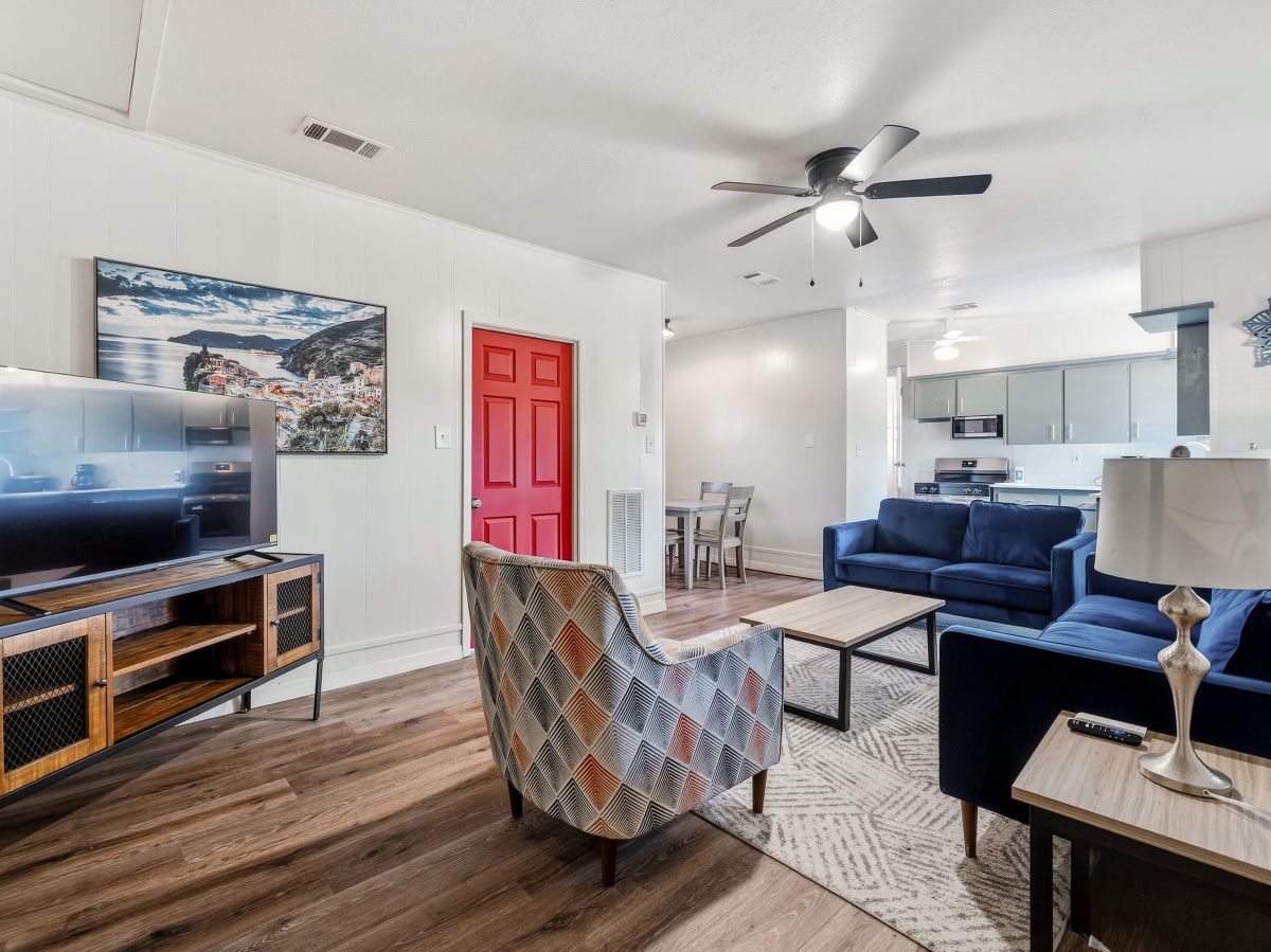 Your open living space flows seamlessly into a bright kitchen, all anchored by warm wood floors and stylish furnishings. Settle into plush seating while the ceiling fan keeps things cool and comfortable.